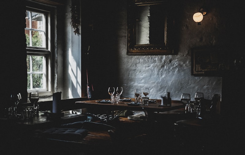 Gedeckter Tisch mit Weingläsern am Fenster