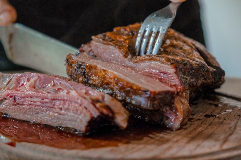 Steak wird auf einem Holzbrett tranchiert